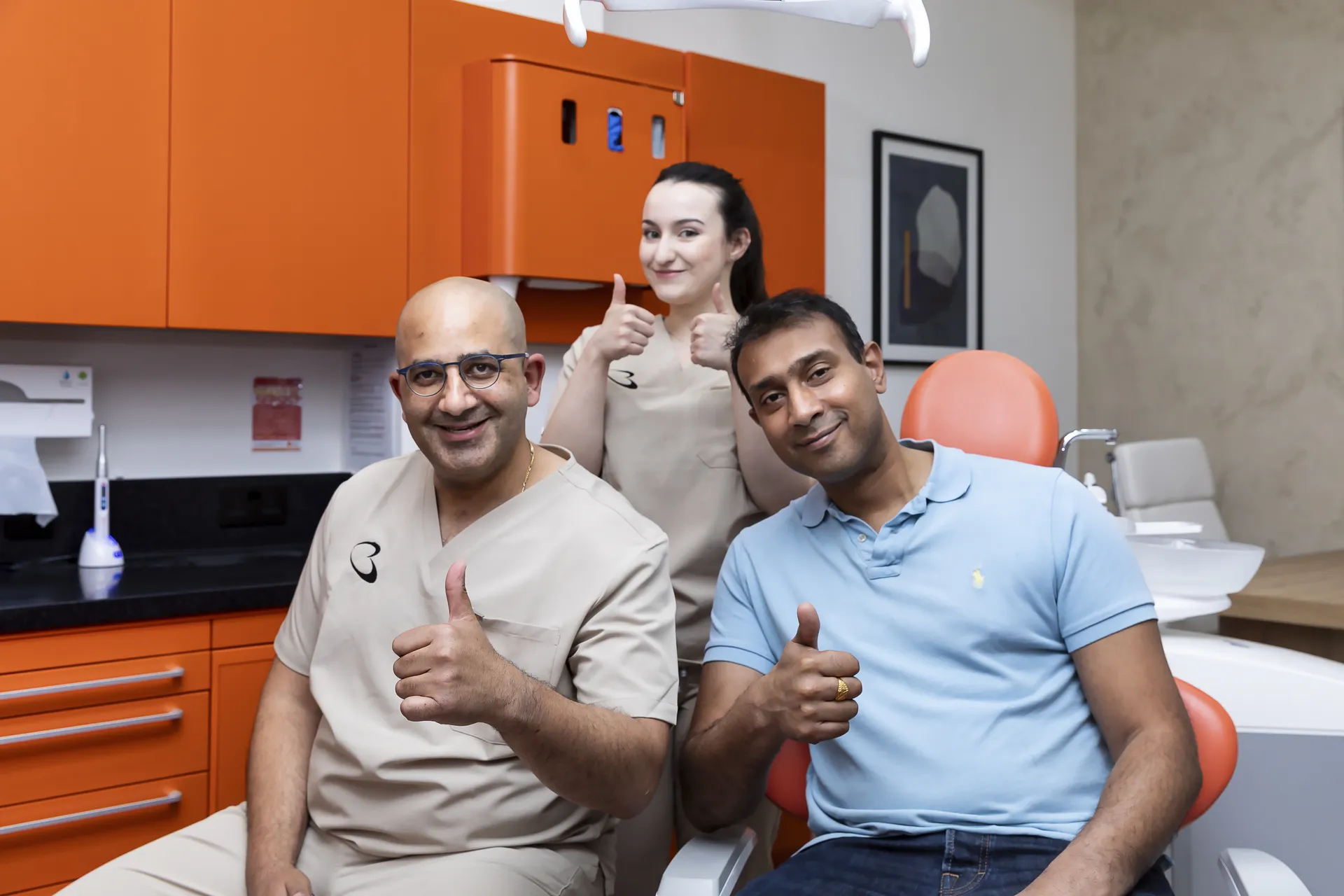 Bella Dental team and patients smiling and giving a thumbs up in the practice